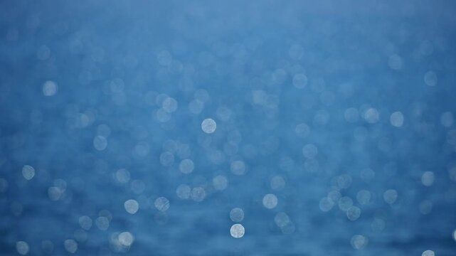 Sea bokeh creates magic. Glowing reflections move slowly. Blurred ocean looks tranquil. Soft glow enhances the water. Sea surface sparkles gently. Bokeh lights drift on waves. Glowing ocean.