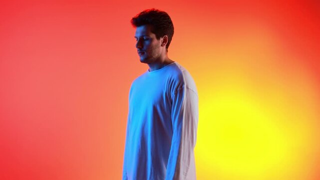Portrait of young man in white shirt under neon colored lighting during 360 rotation. Concept of self confidence, modern masculinity, and bold visual identity for branding and editorial storytelling.