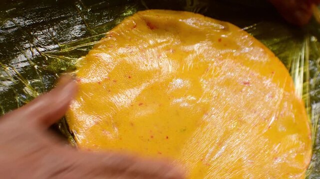 Close up of flattening hallaca dough on banana leaf Venezuelan food
