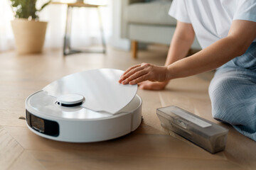 Fototapeta premium White robotic vacuum cleaner on wooden floor