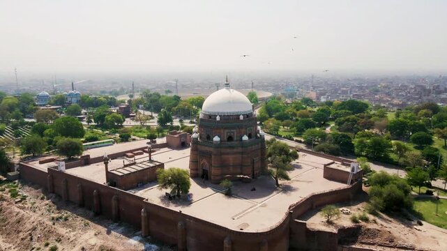 Aerial drone view of the Tomb of Hazrat Shah Rukn-e-Alam in Multan City, Punjab, Pakistan, showcasing historic Islamic architecture and surrounding urban landscape, clear daylight, captured on 6 Augus