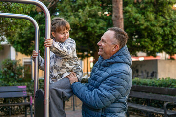 Obraz premium Father playing with nine year old daughter at playground, family bonding and happy childhood concept