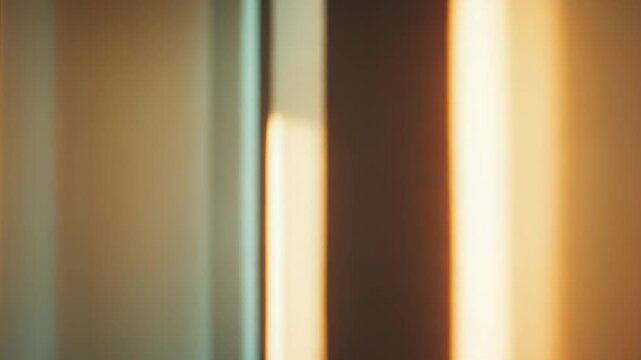 Warm sunlight creating an abstract pattern of bright golden stripes and dark shadows on a textured wall, conveying concepts of illumination, contrast, and interior design