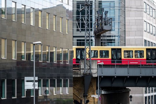 train metro on elevated bridge berlin germany with modern architecture urban transport railway crossing downtown offices in daylight