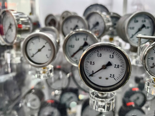 Close view of pressure gauges on display at an industrial fair showing various measurements in a trade exhibition setting