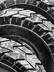 Close view of three rugged tires stacked in a workshop setting during daylight hours
