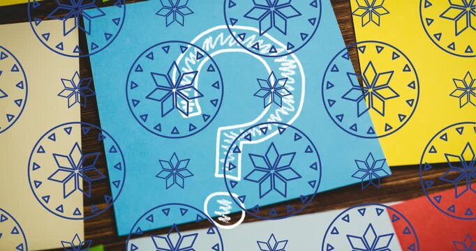 Animation of floral pattern in circles, question mark over multicolored paper on table