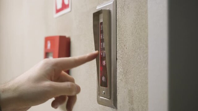Finger pressing numbers on digital keypad intercom to enter access code. Sound of button beeps. Electronic security entry system on building wall. Door access control and security technology.