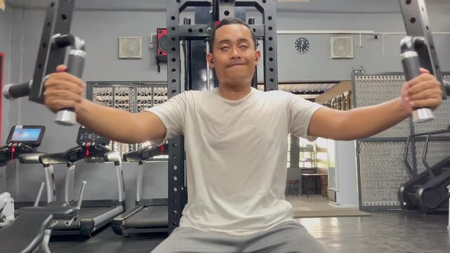 a man using a chest fly machine to train his chest