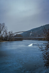 Winter landscape showing a frozen lake covered in ice, surrounded by a quiet natural environment. Winter in the Czech Republic. Vertical Image. 