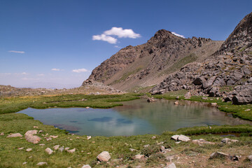 Waterfalls at the Sat Glacier Lakes. Lake landscapes in bloom in spring. Hakkari Cilo Sat Lakes. A lake view in the mountains. Hakkari Cilo Sat Glacier Lakes, mountains covered with flowers.Long expos