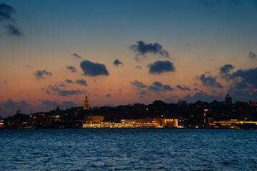 Naklejka premium Karakoy district with Galata tower at sunset, sea view. Evening cruise on Bosphorus. Istanbul, Turkey.