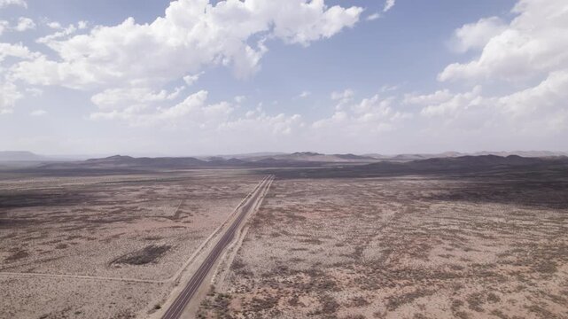 Slow aerial push in on a rural west Texas landscape, an empty highway cuts through the desolate desert