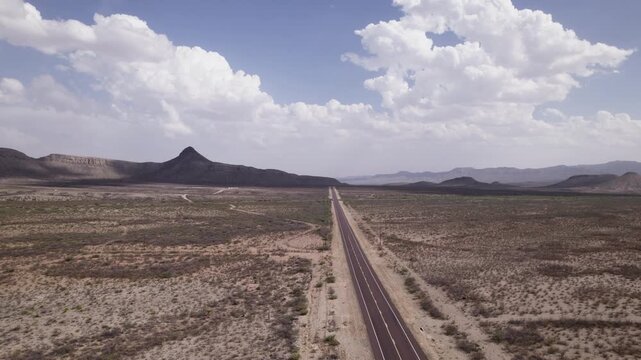 A desert landscape aerial of an empty stretch of highway in the Big Bend region of west Texas