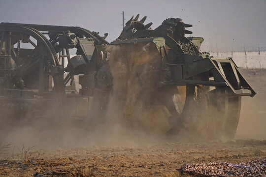 Military special equipment digs a trench in a field. Military exercises.