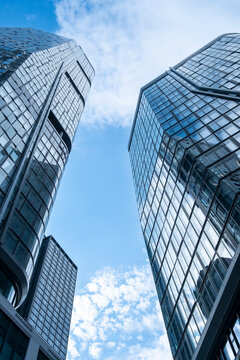 Urban frankfurt wide skyline with modern corporate skyscraper architecture and glass surfaces reflecting soft clouds in daylight today