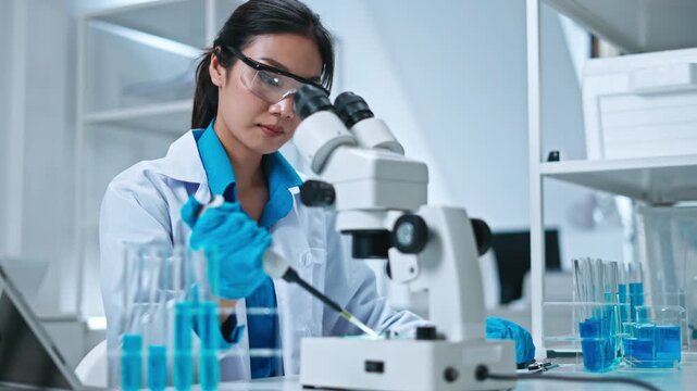 Scientist,Beautiful young woman scientist in laboratory working.female scientist doing some research.report and writing medical results,medicine documents in laboratory for healthcare,science review