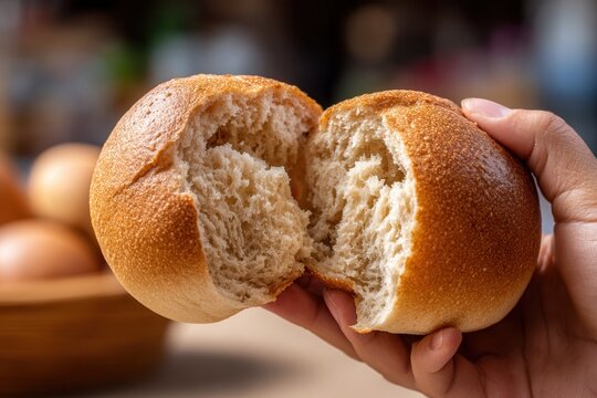 Close-up hand holding guajolota with tamal inside soft bolillo bread.