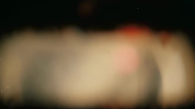 Blurred, abstract image with gradient colors of beige, black, and red, with faint dots