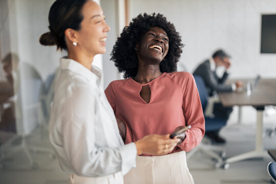 Diverse businesswomen laughing sharing a moment at work