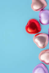 Valentines day and love background, Chocolate hearts with red and pink foil wrapped on blue background, copy space