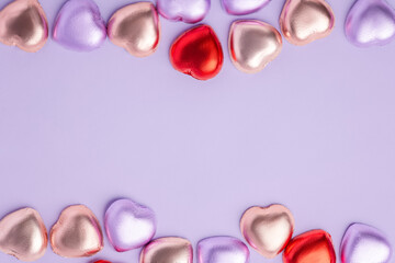 Heart chocolate with colorful foil wrapped on purple background, Valentines day and love concept, copy space