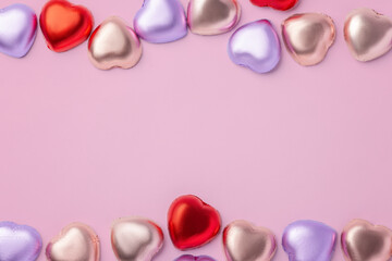 Heart chocolate with colorful foil wrapped on pink background, Valentines day and love concept, top view