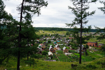 Forest trees framing a peaceful garden village below
