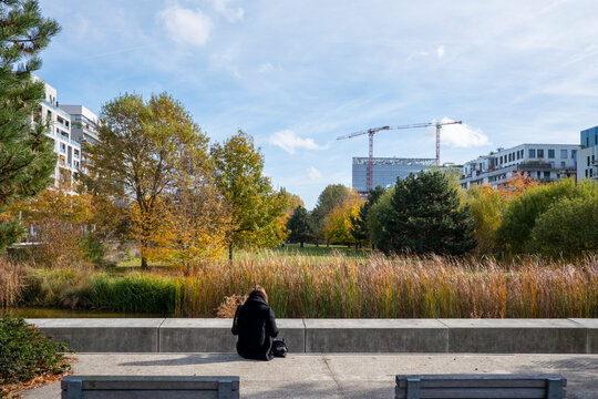 Quiet residential architecture in Boulogne Billancourt Paris France by urban water with reeds in autumn and a person backview on the promenade