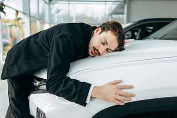Happy bearded man hugging his new white car