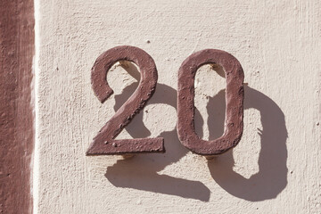 Hausnummernschild Nr. 20 aus Metall auf einer weissen Hauswand, Deutschland