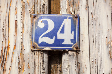 Hausnummernschild Nummer 24 auf einer alten Holzwand, Deutschland