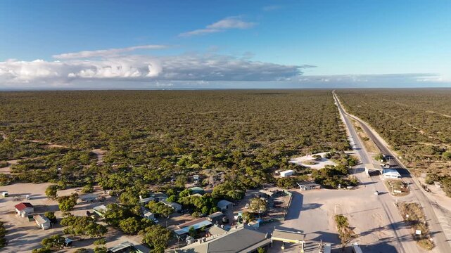 Border Village between South Australia and Western Australia, Eyre Highway, Nullarbor Plain: 4K aerial drone footage of remote roadhouse, boder control, Vehicles, outback highway and vast wilderness