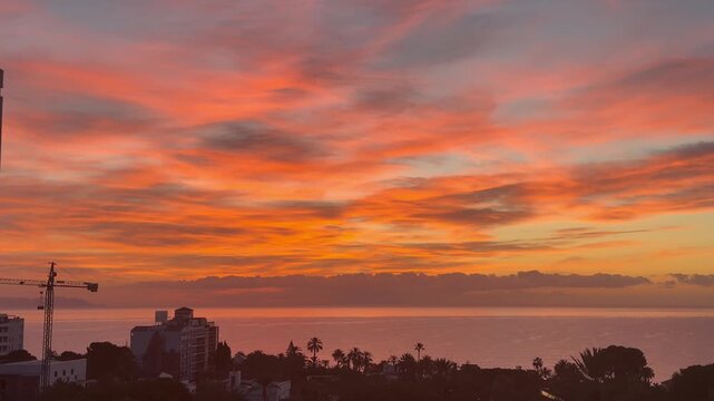 AMANECER ROJO CON VISTAS DE LA CIUDAD Y EL MAR 