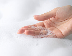 Close-up of Hand Touching Thick Creamy Soap Foam with Tiny Bubbles