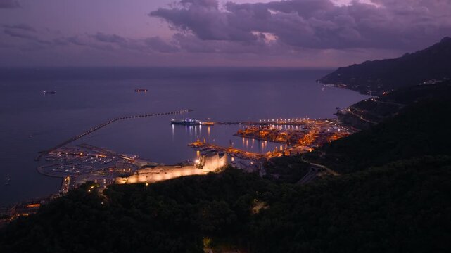 Aerial view of the illuminated Arechi Castle and the port of Salerno, dusk