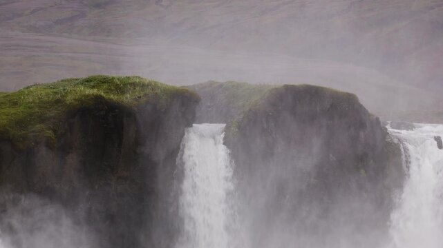 Close up of the center of Godafoss Waterfall in Northern Iceland, water pours through a a gap in the rocks and sprays in to the air