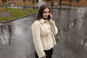 Adult girl talking on the phone in the park