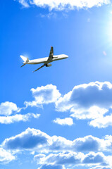 Airpane flying and taking off in the sky over the fluffy cumulus clouds, air travel background