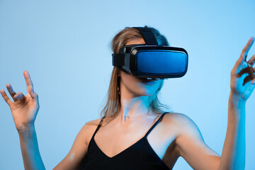 Woman wearing VR headset with raised hands, immersive virtual reality experience, metaverse gaming...