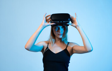 Portrait of woman adjusting virtual reality headset while experiencing immersive digital...