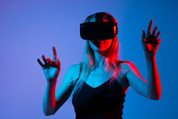Woman using VR headset with both hands raised, virtual interaction and immersive metaverse...