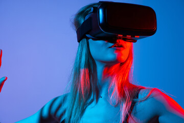 Woman using VR headset in virtual environment, immersive digital experience with neon red blue...