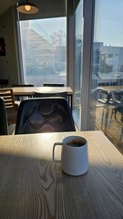 햇살이 비치는 카페 창가의 커피 한 잔