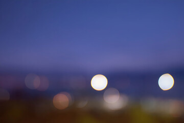 夜景の輝きが作り出す紫と青の幻想的な玉ボケ背景