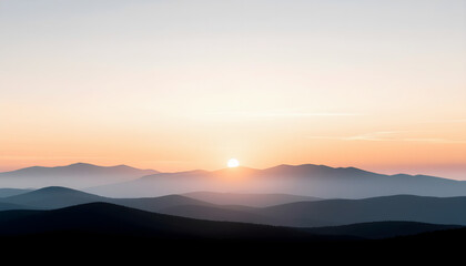 Layered mountain silhouettes in warm sunrise haze