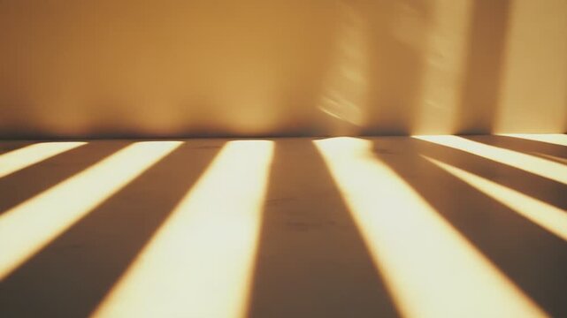 Warm sunlight streams through a window, casting long, parallel shadow lines across an empty room's floor and wall, forming a minimalist and abstract composition