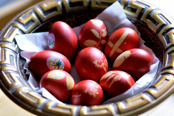 Decorative bowl filled with colorful red Easter eggs adorned with intricate designs
