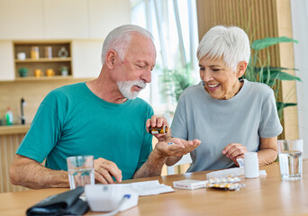 Portrait of a senior couple man and woman  holding drug instructions or prescription beforetaking pills at home