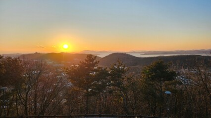 해 질 녘 산과 바다 위로 퍼지는 황금빛 노을